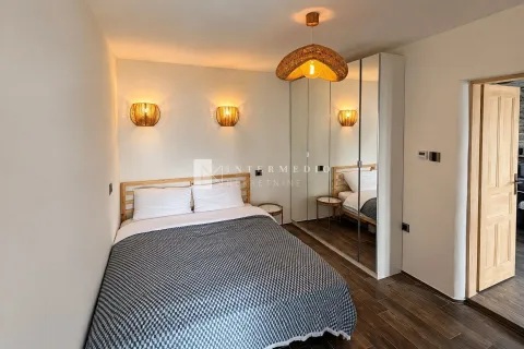 Moderna spavaća soba sa bračnim krevetom, garderoberom sa ogledalima i ukrasnim zidnim lampama. - image 8