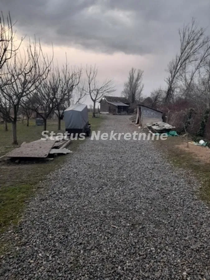 Šljunkoviti prilazni put sa dvorištem i pomoćnim objektima.