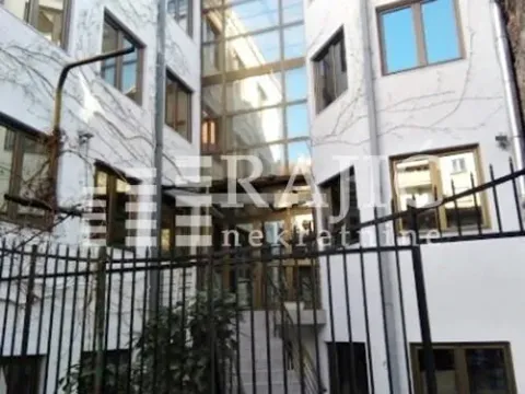 Exterior view of the building with a courtyard and fence. - image 4