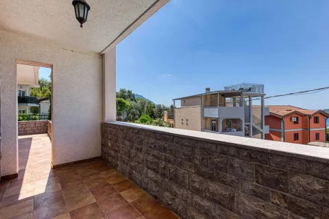 Natkriveni balkon sa popločanim podom i pogledom na okolne zgrade i pejzaž. - image 20