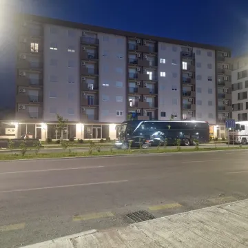 Exterior of an apartment building at night with a street in the foreground. - image 5