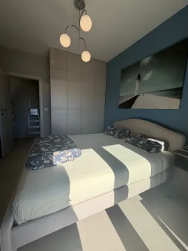 Moderna spavaća soba sa bračnim krevetom, ormarom i slikom na zidu. - image 16