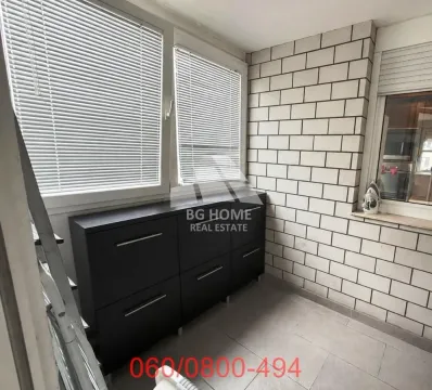 Enclosed balcony with black cabinets and tiled walls. - image 9