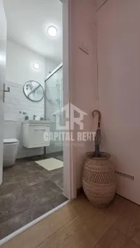 View from the hallway into a modernly decorated bathroom with a walk-in shower. - image 11