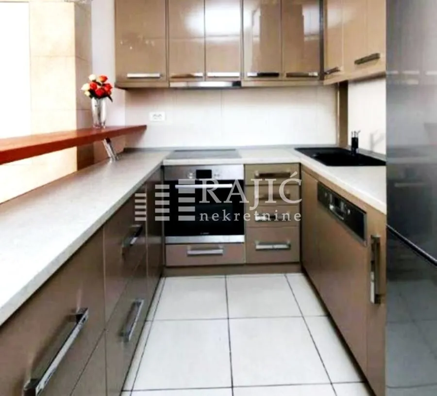 Modern kitchen with brown cabinetry and built-in appliances.