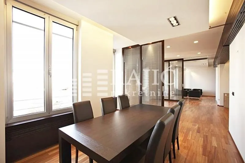 Spacious living room with a dining table and hardwood flooring.