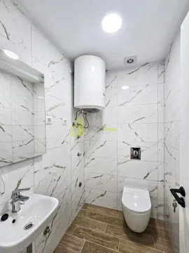 Manje kupatilo obloženo keramičkim pločicama sa umivaonikom, WC šoljom i bojlerom. - image 10