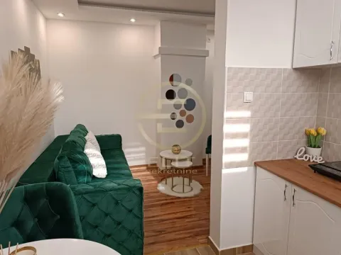 Pogled iz kuhinje na dnevnu sobu sa zelenom sofa garniturom. - image 3