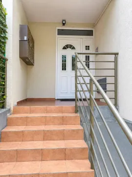 Building entrance with stairs and a metal railing. - image 8