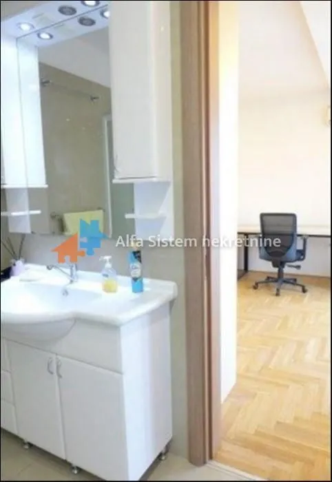 View from the bathroom towards a room with a desk and an office chair.