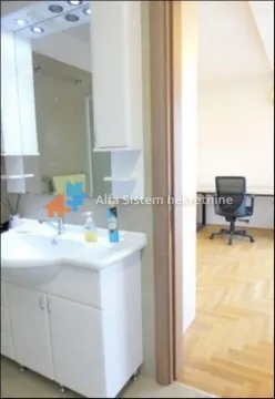View from the bathroom towards a room with a desk and an office chair. - image 7