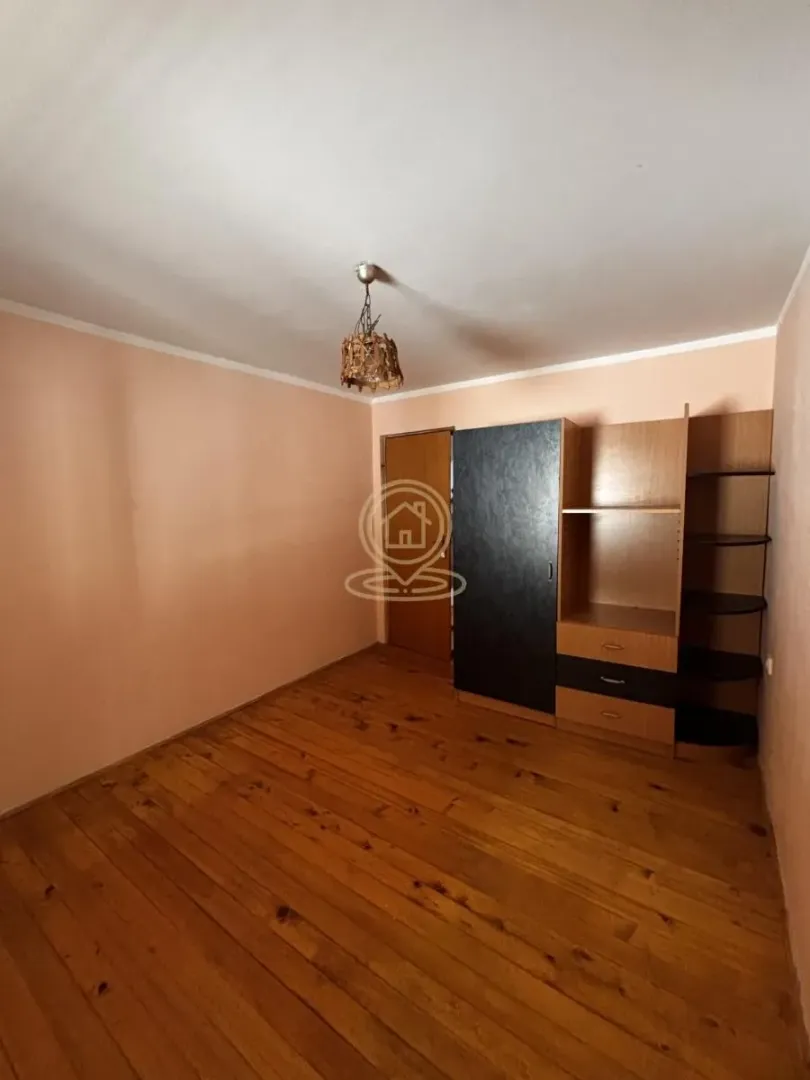 Small bedroom with wooden flooring and a wardrobe.
