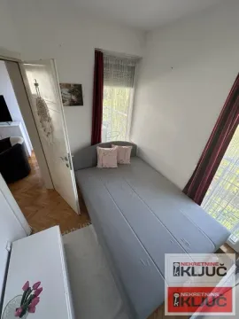 Manja spavaća soba sa krevetom i prozorom koji gleda na terasu. - image 7
