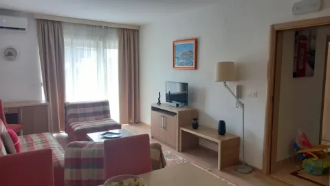 Svijetao dnevni boravak sa garniturom za sjedjenje, televizorom i velikim prozorom. - image 12