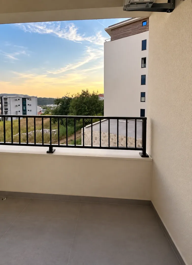 View from the balcony towards surrounding buildings and landscape.