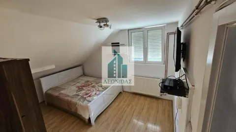 Attic bedroom with a double bed, TV, and sloping ceiling. - image 7