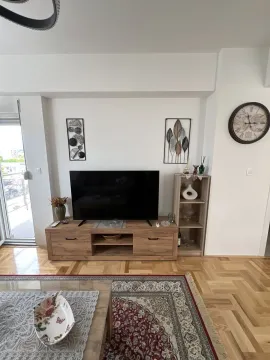 Bright living room featuring a wooden TV stand and parquet flooring. - image 5