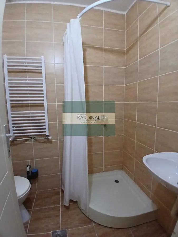 Kupatilo obloženo keramičkim pločicama sa tuš kabinom, WC šoljom i umivaonikom.