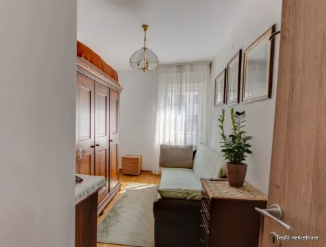 Manja spavaća soba sa krevetom, drvenim ormarom i prozorom. - image 17