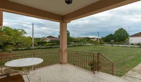 Covered terrace with a view of the grassy yard and surroundings. - image 13