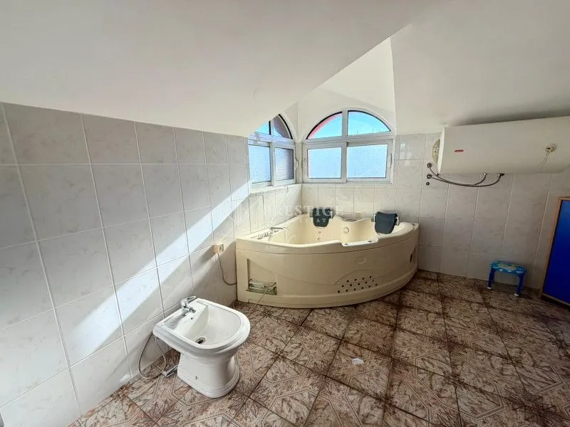 Spacious bathroom with a built-in corner bathtub and bidet.