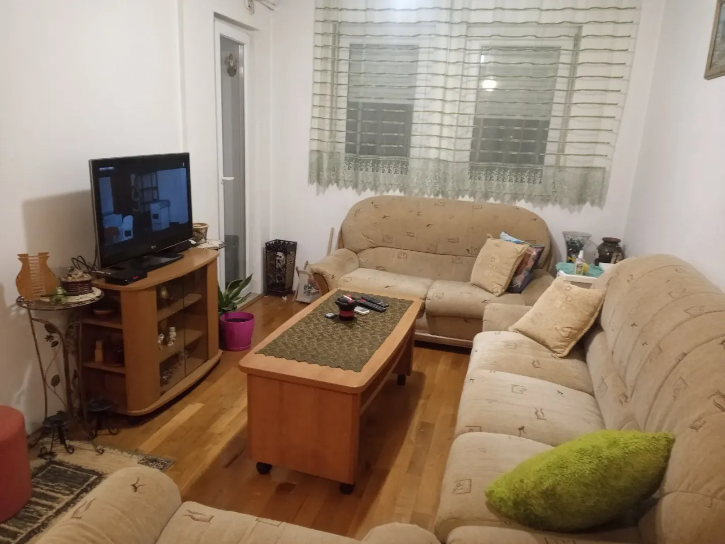 Dnevna soba sa garniturom za sjedenje, klub stolom i televizorom.