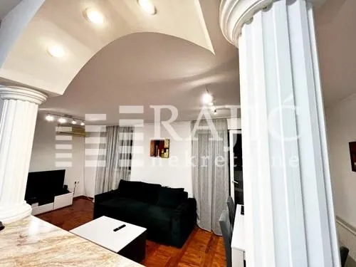 Living room with a sofa and decorative pillars.