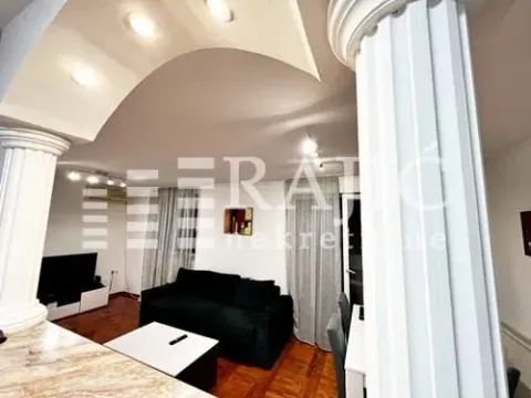 Living room with a sofa and decorative pillars. - image 5