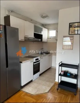 Smaller kitchen with white cabinetry, stove, and refrigerator. - image 4