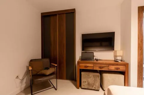 Bedroom with a bed, wardrobe, desk, and wall-mounted TV. - image 12