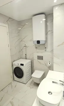Modernly equipped bathroom with washing machine, toilet bowl and washbasin. - image 6