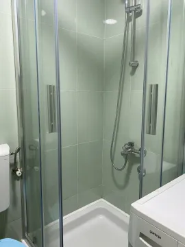 Bathroom with a shower cabin and light green tiles. - image 8