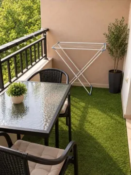 Manji namješteni balkon sa stolom, stolicama i vještačkom travom. - image 6