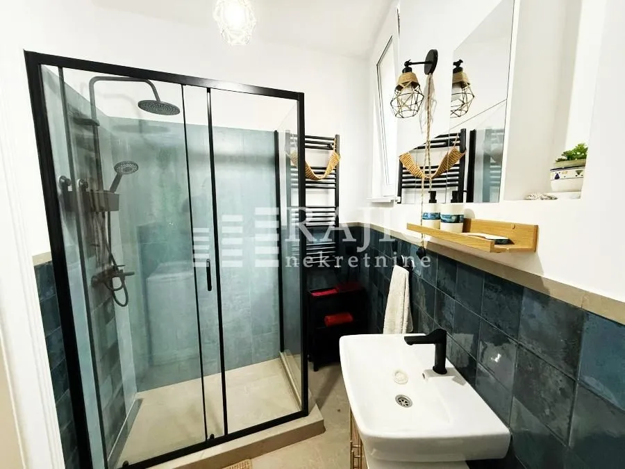 Modern bathroom with a shower cabin and a washbasin.
