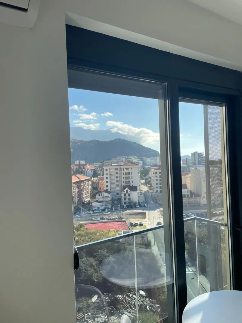 Pogled sa prozora na grad i okolne planine.