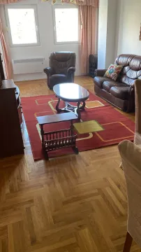 Dnevna soba opremljena kožnim garniturama, drvenim stočićem i parketom na podu. - image 11