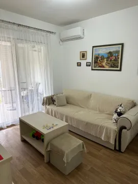 Dnevna soba sa garniturom, stočićem i balkonskim vratima. - image 3