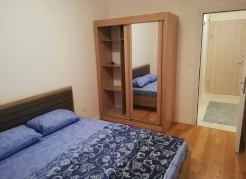 Furnished bedroom with a double bed and a wooden wardrobe. - image 7