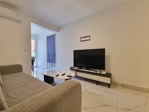 Dnevna soba sa garniturom, TV-om i izlazom na terasu. - image 12