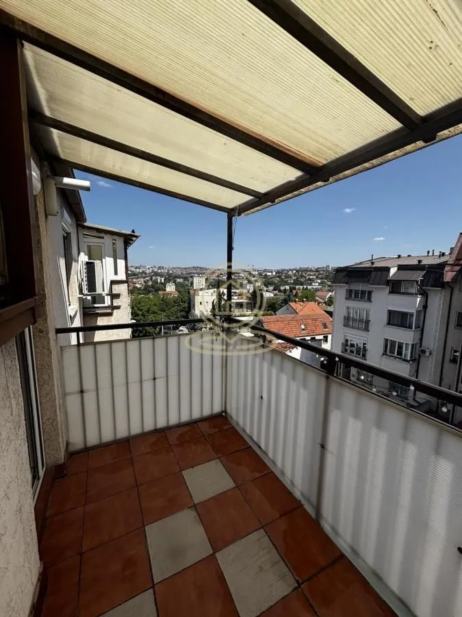 Covered balcony with tiled floor and a view of surrounding buildings and neighborhood.