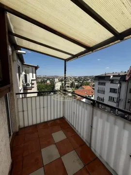 Covered balcony with tiled floor and a view of surrounding buildings and neighborhood. - image 16