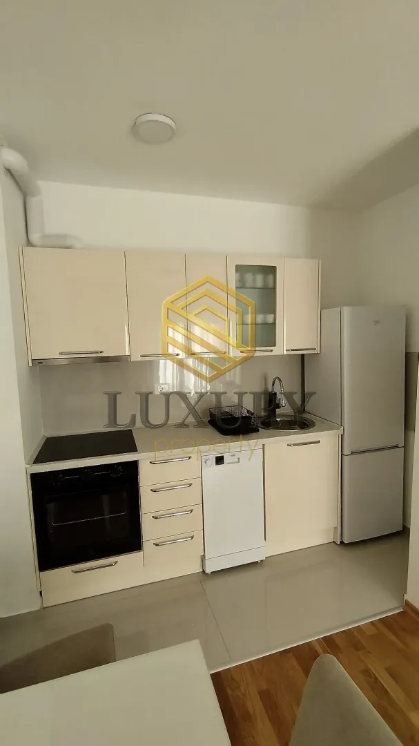Small bright kitchen with fitted units and white goods.