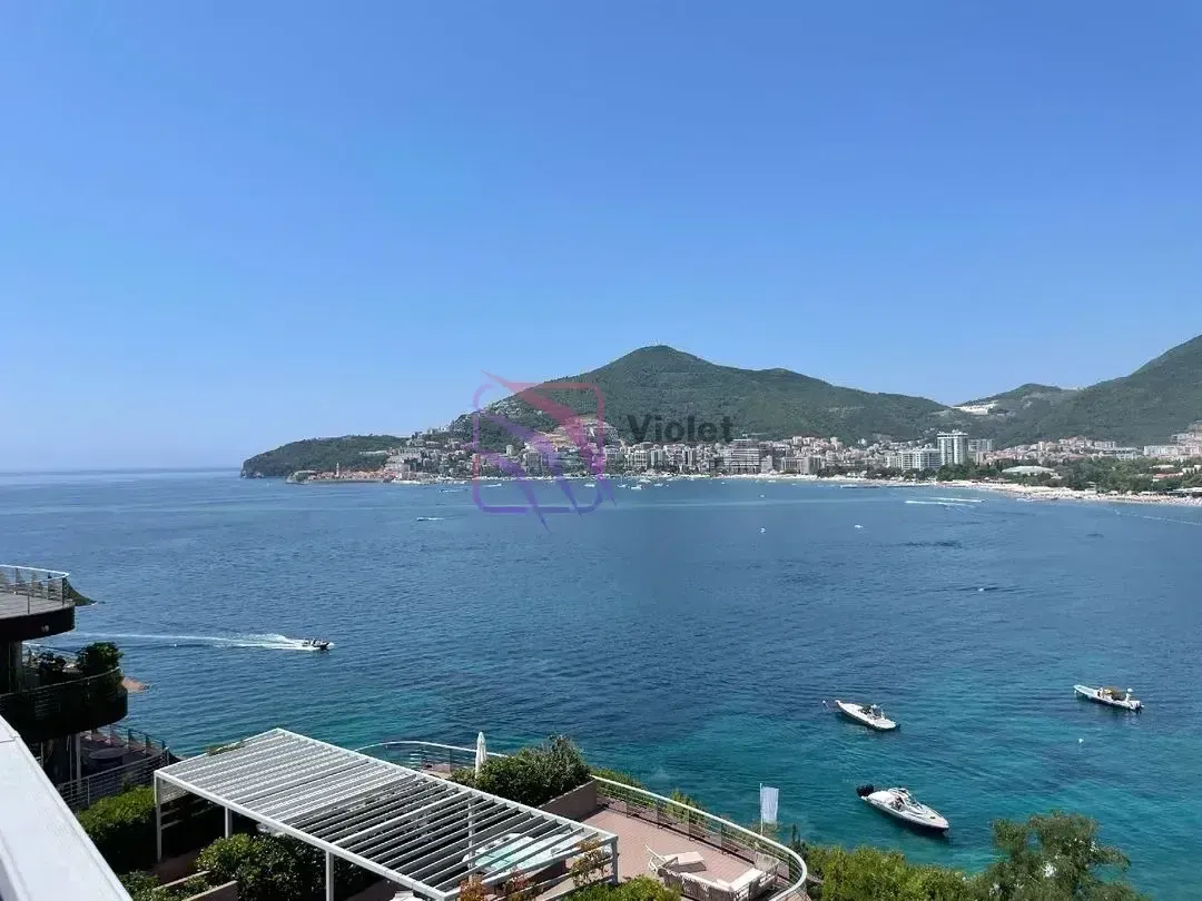 Pogled sa terase na more, obalu i planine u pozadini.