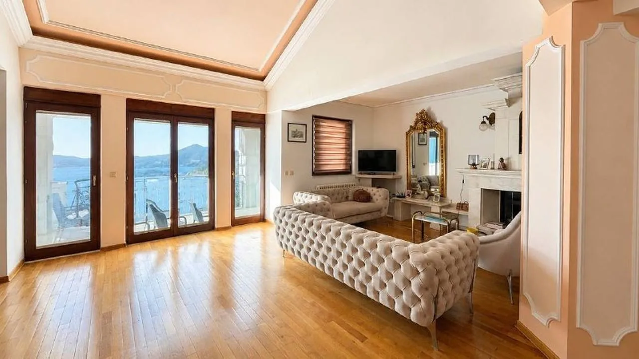Spacious living room with sofa set, fireplace and access to a terrace with sea view.