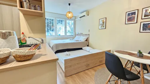 Glavna spavaća soba sa krevetom i malom kuhinjom. - image 3