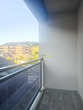 Unfurnished covered balcony with a view of surrounding buildings and greenery. - image 3