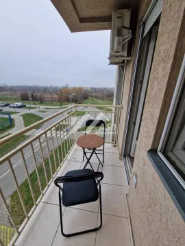 Manji namešteni balkon sa stolom i stolicama i pogledom na okolinu. - image 10
