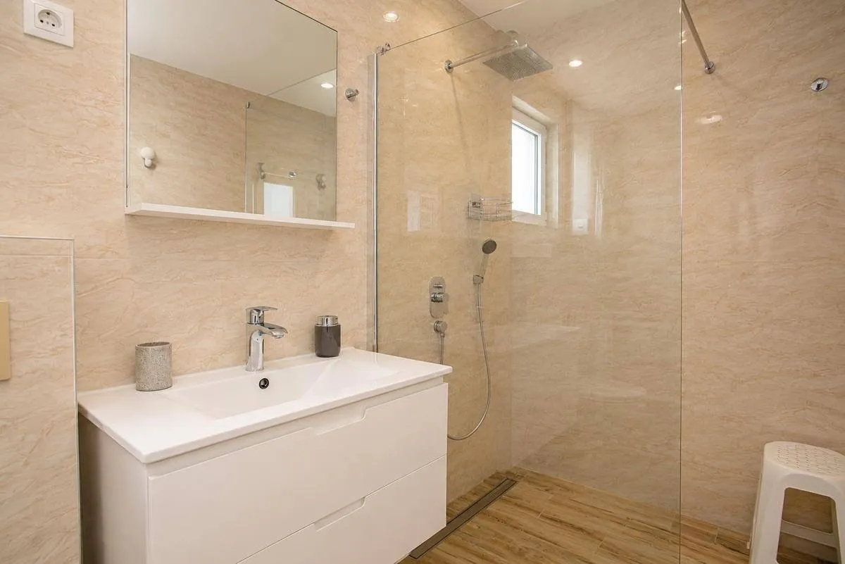 Modern bathroom with a sink and a glass-enclosed shower.