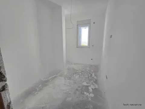 Prazna prostorija u izgradnji sa belim zidovima i jednim prozorom. - image 6
