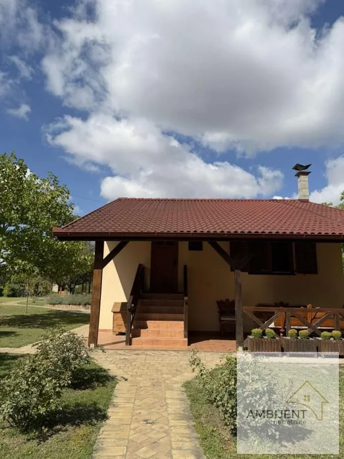 Pogled na dvorište i prednji deo kuće sa natkrivenom terasom.